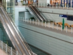 Lång rulltrappa. Där längst ner går tåget ut till gaterna längst bort